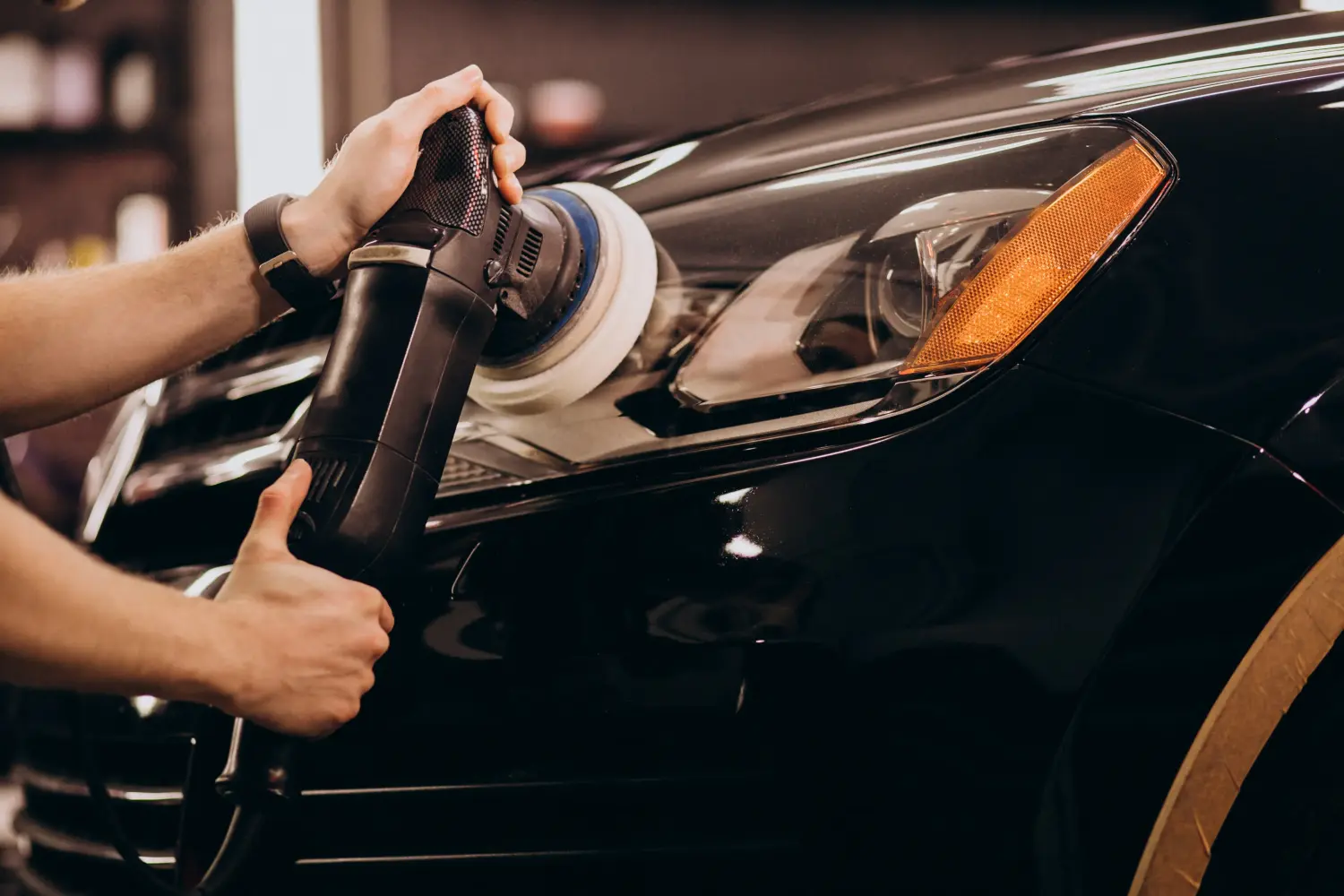 Autoaufbereitung, insbesondere das Polieren der Außenseite eines schwarzen Autos mit einer Rotations- oder Exzenterpoliermaschine.